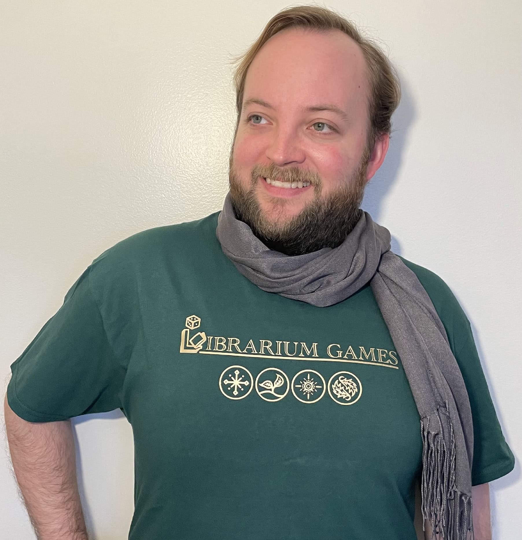 This is a photograph of Alexander Massar, modeling the Calendra T-Shirt for the Librarium Games Store